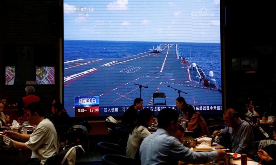 A giant screen at a restaurant in Beijing shows news footage of the Chinese military taking part in exercises around Taiwan.