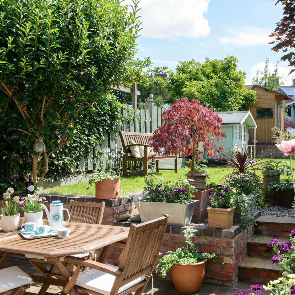 A garden with steps and wooden garden furniture