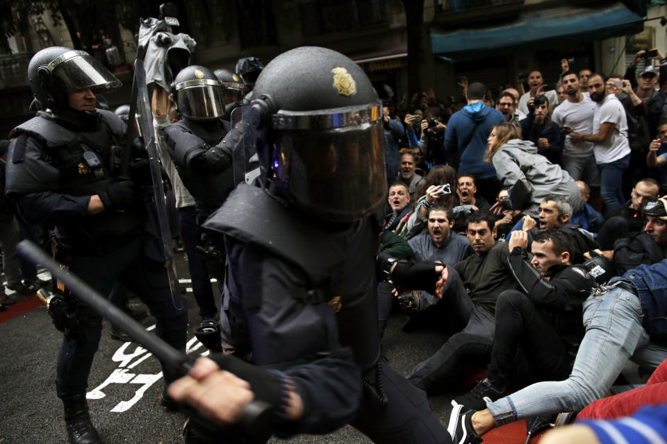 Spanish National Police tries to dislodge pro-referendum supporters sitting down on a street in Barcelona. (AP Photo/Manu Fernandez)