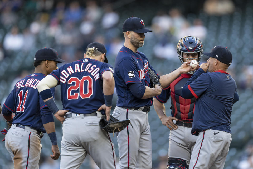 Minnesota Twins starting pitcher J.A. Happ, center, meets at the mound with pitching coach Wes Johnson, right, shortstop Jorge Polanco (11), third baseman Josh Donaldson and catcher Ben Rortvedt during the second inning of a baseball game against the Seattle Mariners, Tuesday, June 15, 2021, in Seattle. (AP Photo/Stephen Brashear)