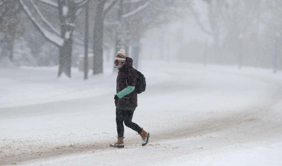 A pedestrian makes her way across empty Speer Blvd. as a storm packing snow and high winds sweeps in over the region Tuesday, Nov. 26, 2019, in Denver. Stores, schools and government offices were closed or curtailed their hours while on another front, Thanksgiving Day travellers were forced to wrestle with snow-packed roads and flight delays or cancellations throughout the intermountain West. (AP Photo/David Zalubowski)