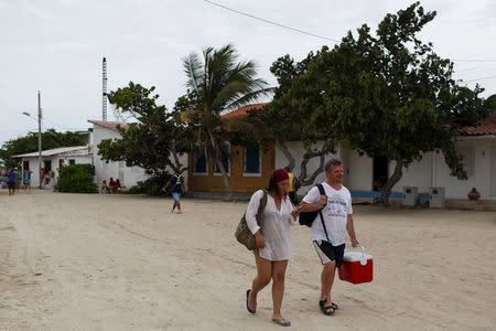 Tourists walk on the street at the Gran Roque island, in the archipelago of Los Roques May 29, 2015. REUTERS/Carlos Garcia Rawlins