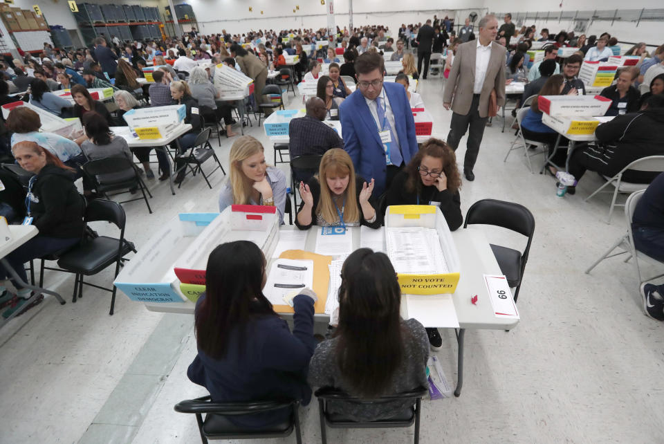 FILE- In this Nov. 16, 2018, file photo workers at the Broward County Supervisor of Elections office show Republican and Democrat observers ballots during a hand recount in Lauderhill, Fla. As Florida's elections supervisors meet for the first time since the Nov. 6 election, they say that despite some recent problems, the majority of the counties handled things smoothly.. (AP Photo/Wilfredo Lee, File)