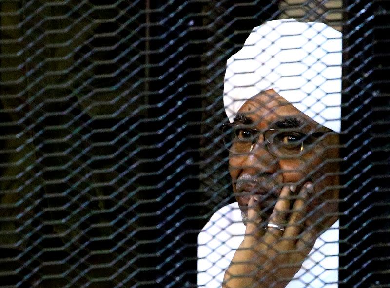 Sudan's former president Omar Hassan al-Bashir sits inside a cage at the courthouse where he is facing corruption charges, in Khartoum