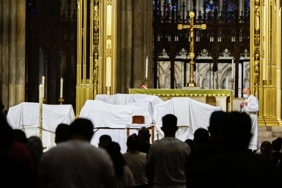 FILE - In this Saturday, July 11, 2020 file photo, mourners attend the blessing of ashes of Mexicans who died from COVID-19 during a payer a service at St. Patrick's Cathedral in New York, before they were repatriated to Mexico. The Roman Catholic Archdiocese of New York issued a statement in the summer of 2021, saying that any priest issuing an exemption letter would be “acting in contradiction” to statements from Pope Francis that receiving the vaccine is morally acceptable and responsible. (AP Photo/Eduardo Munoz Alvarez)