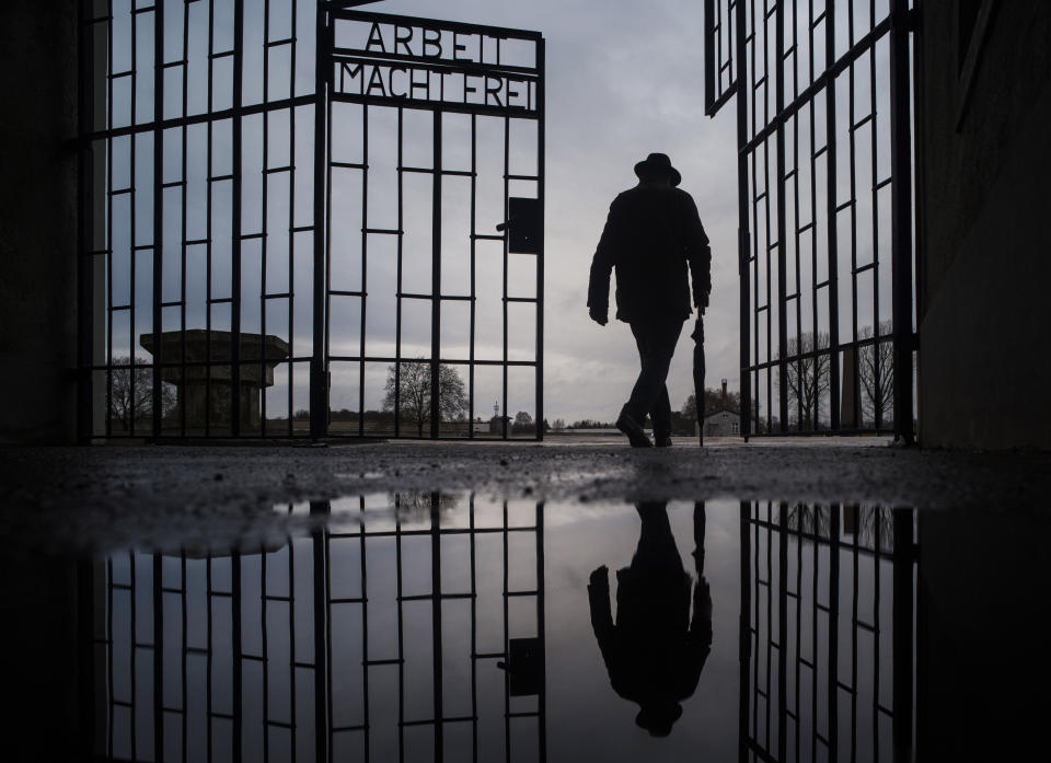 -File- In this Sunday, Jan. 27, 2019 file photo a man walks through the gate of the Sachsenhausen Nazi death camp with the phrase 'Arbeit macht frei' (work sets you free) at the International Holocaust Remembrance Day, in Oranienburg, about 30 kilometers, (18 miles) north of Berlin, Germany. The Department for Research and Information on Anti-Semitism Berlin, or RIAS documented 410 incidents in Berlin, more than two a day, in the first half of 2020, including physical attacks, property damage, threats, harmful behavior and anti-Semitic propaganda. (AP Photo/Markus Schreiber, file)