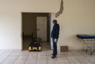 A mortuary worker stands next to a coffin carrying the body of a person who died of COVID-19 ahead of a funeral home in Vereeniging, east of Johannesburg, South Africa, Saturday, Feb. 6, 2021. (AP Photo/Themba Hadebe)