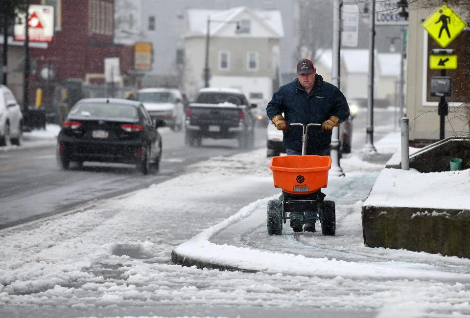 Kevin Chviruk, senior custodian at Quinsigamond Elementary School in Worcester, puts ice melt on the sidewalks Thursday morning.