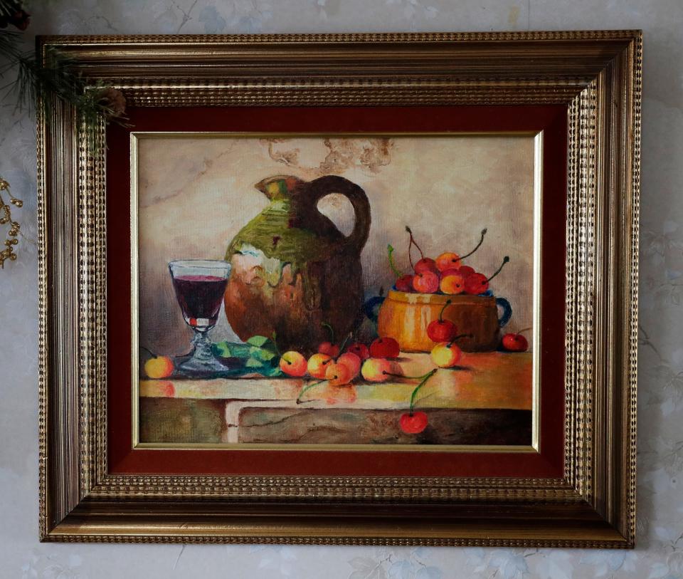 A painting of a wine jug surrounded by cherries painted by Germaine Smith, who turned 100 on Jan. 8, hangs in the kitchen of her home on Jan. 18, 2023, in Wrightstown, Wis.