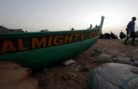 A man walks past a boat on the beach in the township of West Point, in Monrovia, Liberia, October 18, 2017. REUTERS/Thierry Gouegnon