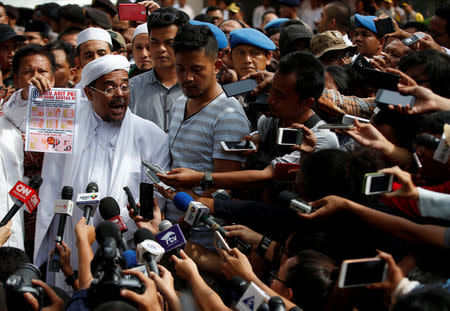 The leader of the hardline Islamic Defenders Front (FPI), Habib Rizieq, speaks to journalists at police headquarters following his questioning by police over his claims that new bank notes contain symbols resembling the Communist hammer and sickle, which are illegal, in Jakarta, Indonesia January 23, 2017. REUTERS/Darren Whiteside
