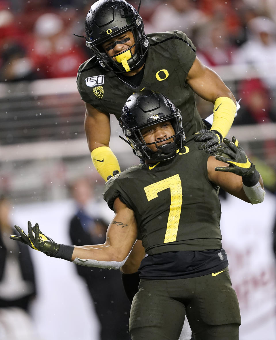 Oregon running back CJ Verdell (7) celebrates with Johnny Johnson III, top, after scoring a touchdown against Utah during the second half of an NCAA college football game for the Pac-12 Conference championship in Santa Clara, Calif., Friday, Dec. 6, 2018. Oregon won 37-15. (AP Photo/Tony Avelar)