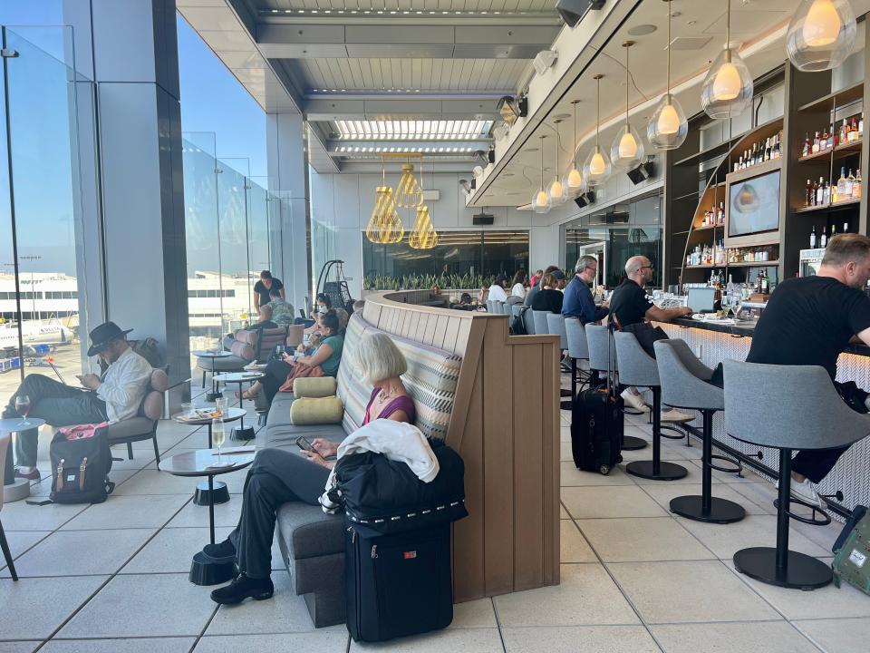 The Sky Club deck with the bar on the right and seating overlooking the tarmac to the left.