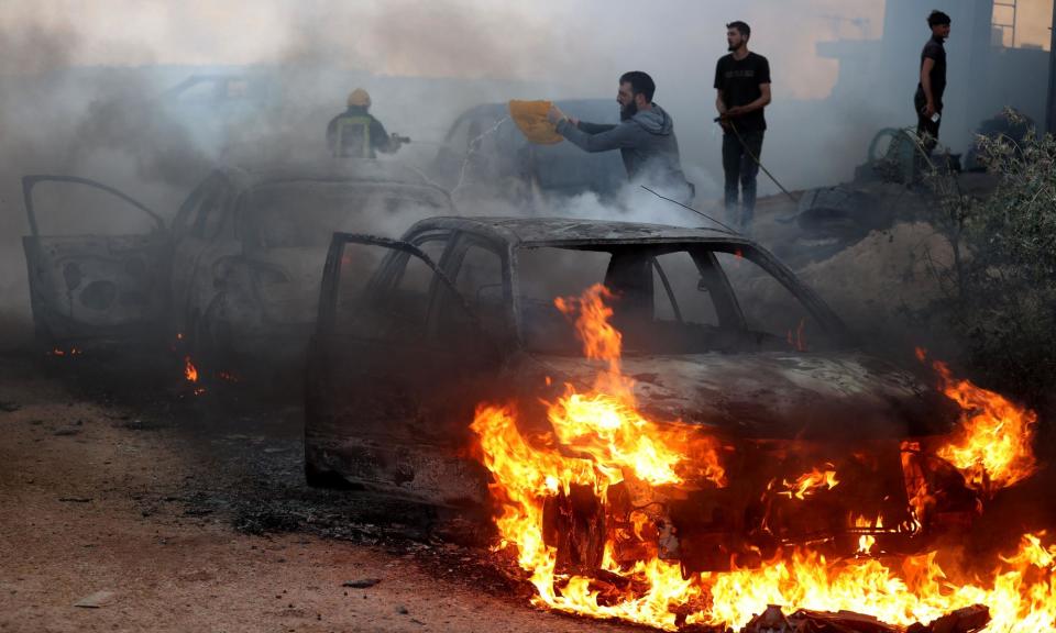 <span>Damaged houses and vehicles left burning after a raid by Jewish settlers on a town near Ramallah in the West Bank in April.</span><span>Photograph: Anadolu/Getty Images</span>