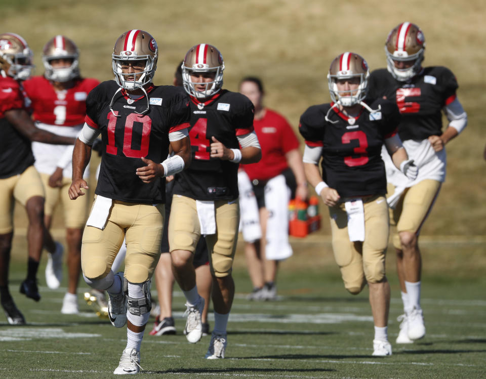 San Francisco 49ers quarterback Jimmy Garoppolo leads quarterbacks through a drill during a combined NFL training camp with the Denver Broncos Saturday, Aug. 17, 2019, at the Broncos' headquarters in Englewood, Colo. (AP Photo/David Zalubowski)