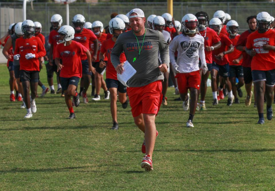 St. Lucie West Centennial High School football coach Josh Watkins, center, leads his team back on to the field after a water break during practice on Monday, Aug. 2, 2021, in Port St. Lucie.