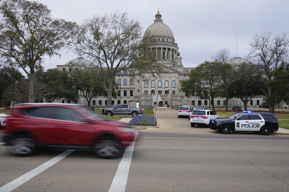 Traffic rolls past the Mississippi State Capitol in Jackson, Miss., as Capitol Police respond to a bomb threat within the building, Wednesday mornin, Jan. 3, 2024. The building was emptied, the grounds cleared of vehicles as officers investigated. (AP Photo/Rogelio V. Solis)