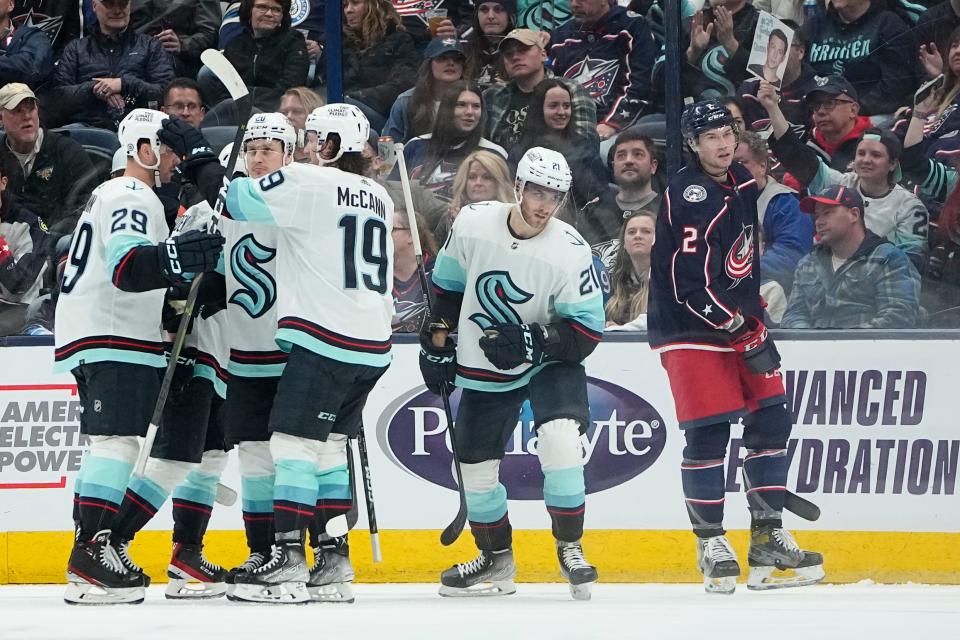 Mar 3, 2023; Columbus, Ohio, USA;  Seattle Kraken center Alex Wennberg (21) celebrates scoring a goal with teammates in front of Columbus Blue Jackets defenseman Andrew Peeke (2) during the third period of the NHL hockey game at Nationwide Arena. The Blue Jackets lost 4-2. Mandatory Credit: Adam Cairns-The Columbus Dispatch