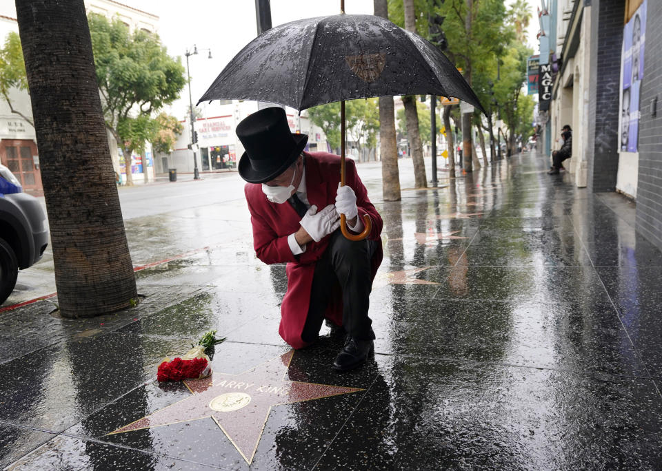 Gregg Donovan, the former ambassador of Beverly Hills and a friend of the late broadcasting giant Larry King for over 30 years, pays his respects at King's star on the Hollywood Walk of Fame, Saturday, Jan. 23, 2021, in Los Angeles. King, the host of "Larry King Live" on CNN for over 25 years, died Saturday at Cedars-Sinai Medical Center in Los Angeles at age 87. "Larry was a legend in all aspects," Donovan said. "Any actor or performer, if you were on 'Larry King Live,' you knew you had made it, that you had arrived." (AP Photo/Chris Pizzello)