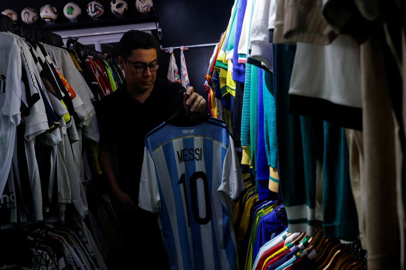 Cassio Brandao, de 41 años, sostiene una camiseta del argentino Lionel Messi, en una sala llena de percheros que en abril de 2024 lo convirtieron en poseedor del título Guinness World Records como propietario de la colección de camisetas de fútbol más grande del mundo. , en Sao Paulo, Brasil, el 24 de junio de 2024