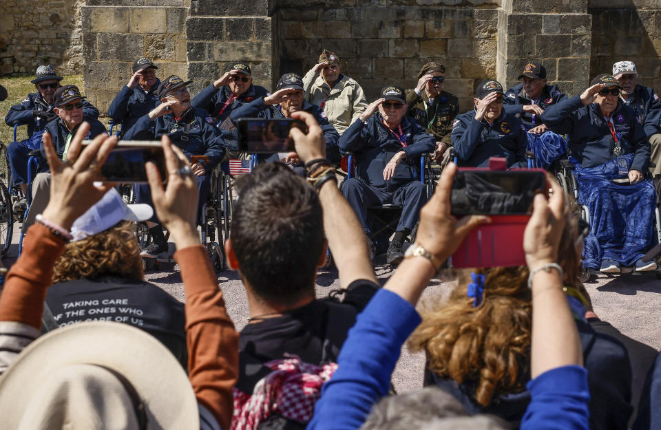 CORRECTS LOCATION U.S. veterans salute as they pose for photographs after a parade in preparation of the 79th D-Day anniversary in Sainte-Mere-Eglise, Normandy, France, Sunday, June 4, 2023. The landings on the coast of Normandy 79 year ago by U.S. and British troops took place on June 6, 1944. (AP Photo/Thomas Padilla)