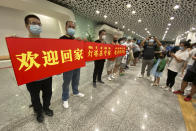 Supporters of Huawei CFO Meng Wanzhou hold a banner reading: "Welcome Home" at Shenzhen Bao'an International Airport in Shenzhen in southern China's Guangdong Province, Saturday, Sept. 25, 2021. China's government was eagerly anticipating the return of a top executive from global communications giant Huawei Technologies on Saturday following what amounted to a high-stakes prisoner swap with Canada and the U.S. (AP Photo/Ng Han Guan)