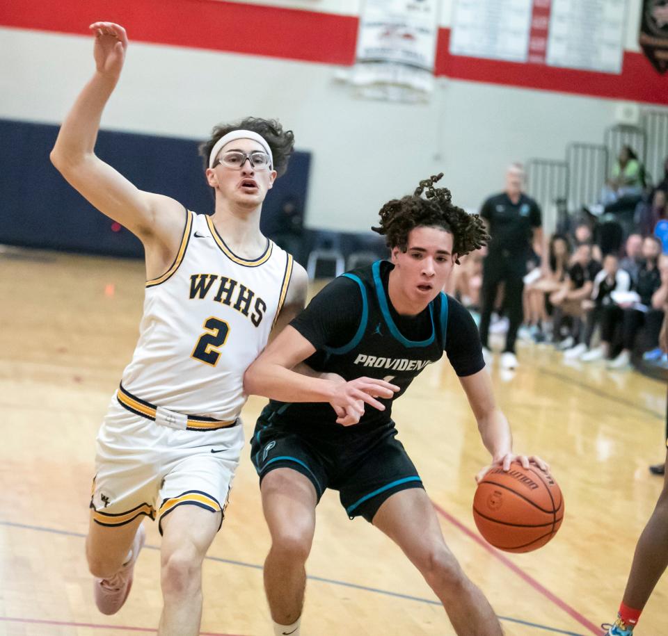 Winter Haven guard Matthew Vaughn (2) and Providence guard Chris Arias (1) tangle during the Kingdom of the Sun basketball tournament in Ocala.