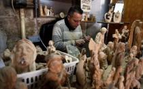 A Palestinian worker carves a figurine for sale during Christmas season, at a workshop in Bethlehem in the occupied West Bank, December 10, 2018. REUTERS/Raneen Sawafta