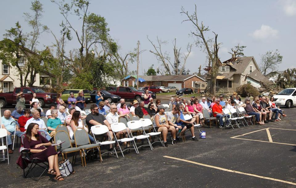 Church members, neighbors, friends and family of the Northridge Wesleyan Church sing during a Sunday service in the parking lot of the tornado damaged church in Harrison Twp. Damaged homes on Neff Road are seen in the background.  (WHIO File)