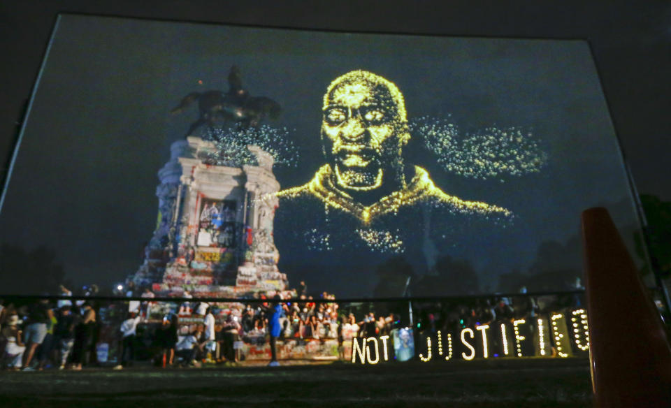 An image of George Floyd is projected on a screen in front of the statue of Confederate General Robert E. Lee on Monument Avenue Tuesday July 28, 2020, in Richmond, Va. Change.org and the George Floyd Foundation officially launched "A Monumental Change: The George Floyd Hologram Memorial Project" in Richmond, the capital of the Confederacy (AP Photo/Steve Helber)