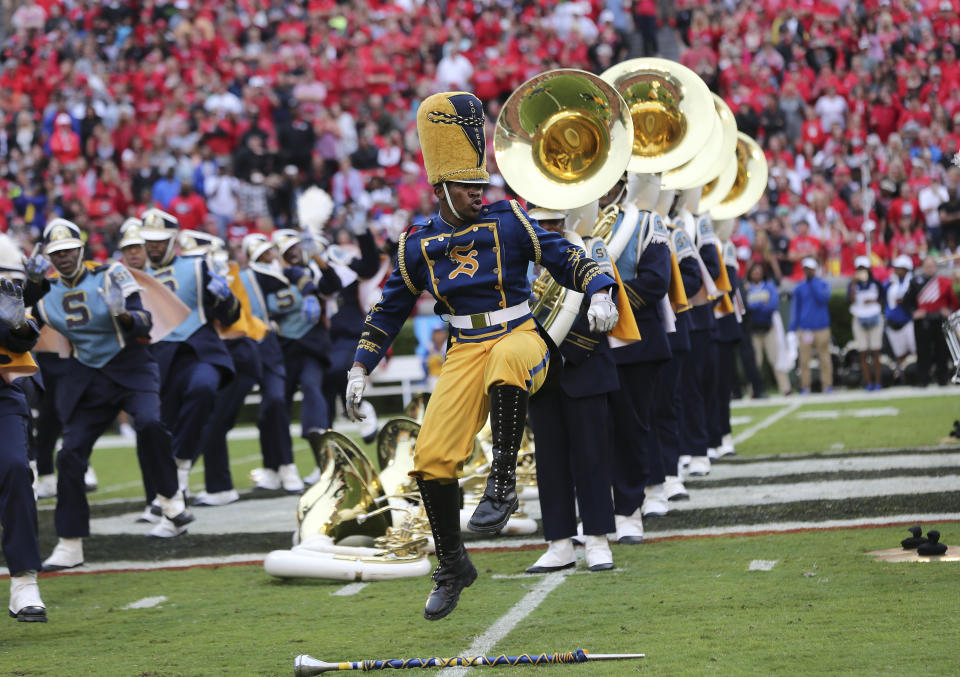 FILE - In this Sept. 26, 2015, file photo, Southern drum major Keith Morgan, of New Orleans, performs with the band during a halftime show an NCAA college football game against Georgia in Athens, Ga. HBCUs across the country earn some money from television contracts. But the primary source of revenue from football comes from putting fans in the stands. Programs could take a huge financial hit if fans are banned from football games this fall. (AP Photo/John Bazemore, File)