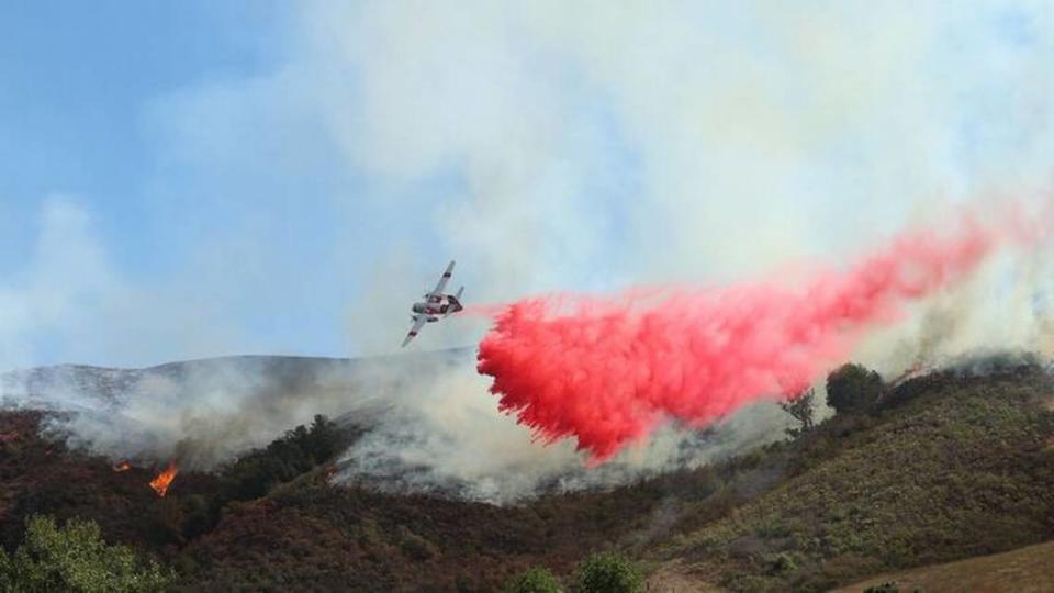 An air tanker drops fire retardant south of Highway 46 near Cambria in October. The seven surplus Coast Guard aircraft sought by the state would be able to carry more retardant than Cal Fire’s current aircraft.