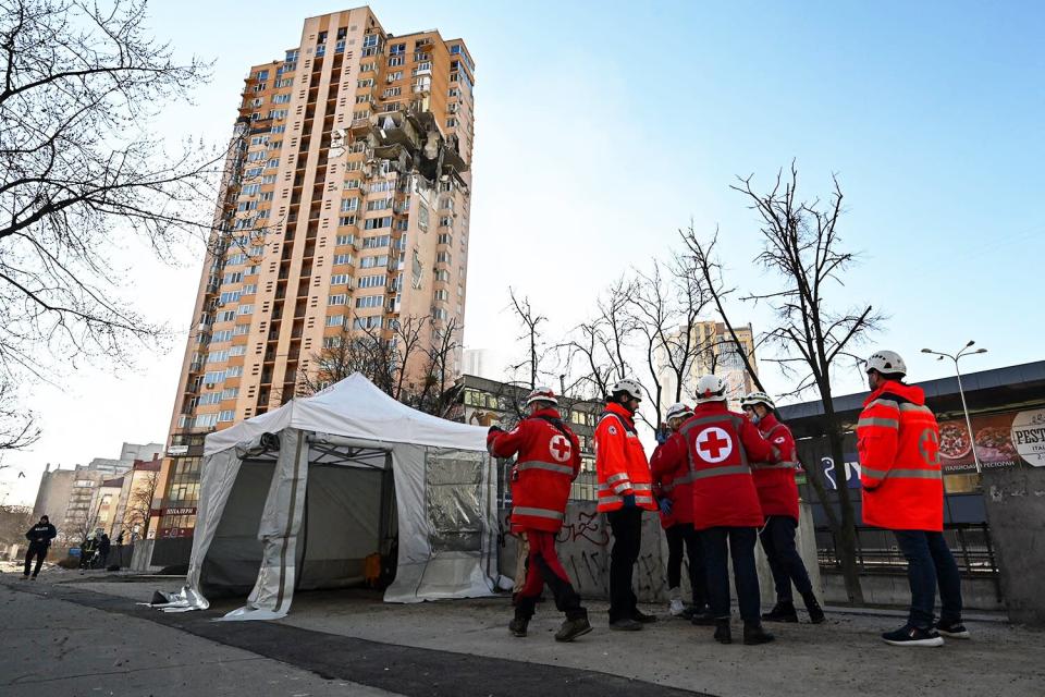 Medics gather by a high-rise apartment block which was hit by recent shelling in Kyiv on February 26, 2022. - Ukrainian soldiers repulsed a Russian attack in the capital, the military said on February 26 after a defiant President Volodymyr Zelensky vowed his pro-Western country would not be bowed by Moscow. It started the third day since Russian leader Vladimir Putin unleashed a full-scale invasion that has killed dozens of people, forced more than 50,000 to flee Ukraine in just 48 hours and sparked fears of a wider conflict in Europe.
