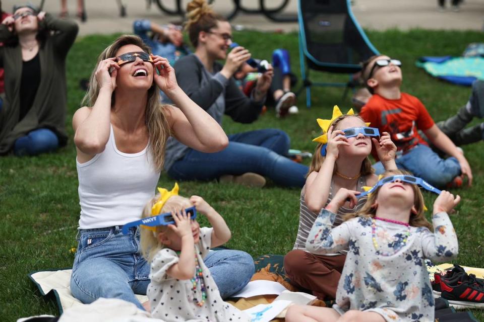 Jessica Lundgaard and her daughters Izzy, Soleil and Layla react as the eclipse emerges from cloud over at Living Arts and Science Center in Lexington, Ky., on April 8, 2024. The area was expected to see around 96% totality. Silas Walker/swalker@herald-leader.com