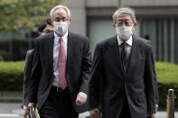 Former Nissan Motor Co. executive Greg Kelly, left, arrives for the first trial hearing at the Tokyo District Court in Tokyo Tuesday, Sept. 15, 2020. The financial misconduct trial of Kelly opened Tuesday. Japanese prosecutors outlined allegations of what they said was a complex and clandestine scheme to pay former star executive Carlos Ghosn. (Kiyoshi Ota/Pool Photo via AP)