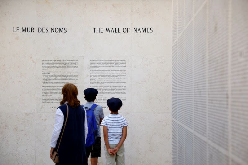 Visitors stand in front of the Wall of Names at the Shoah Memorial in Paris