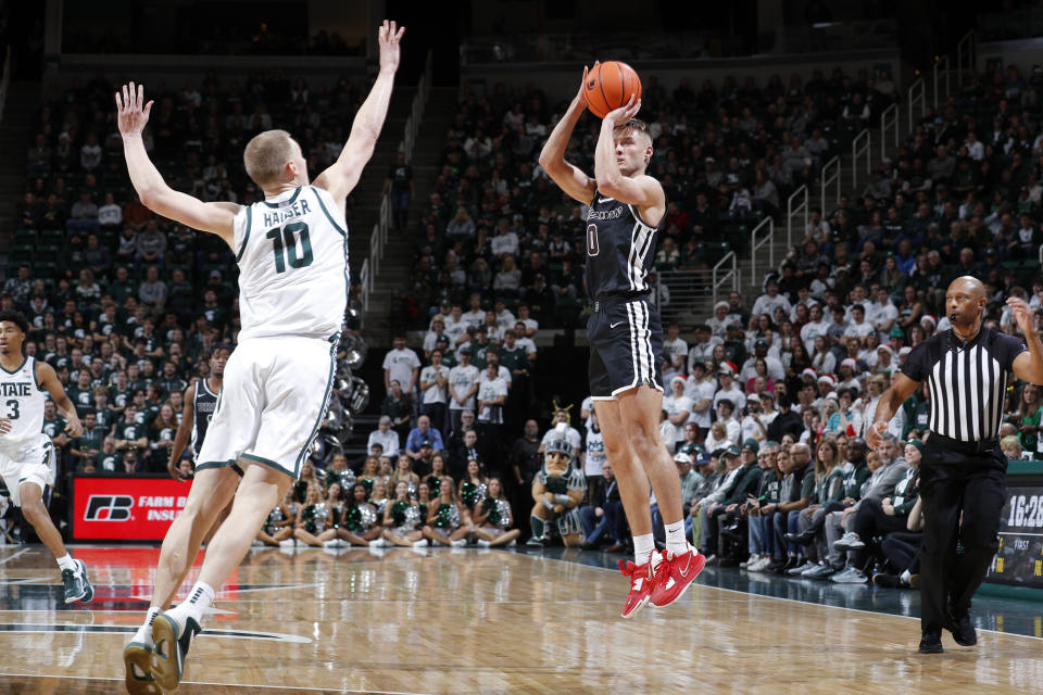 Brown's Paxson Wojcik, right, shoots against Michigan State's Joey Hauser (10) during the first half of an NCAA college basketball game, Saturday, Dec. 10, 2022, in East Lansing, Mich. (AP Photo/Al Goldis)