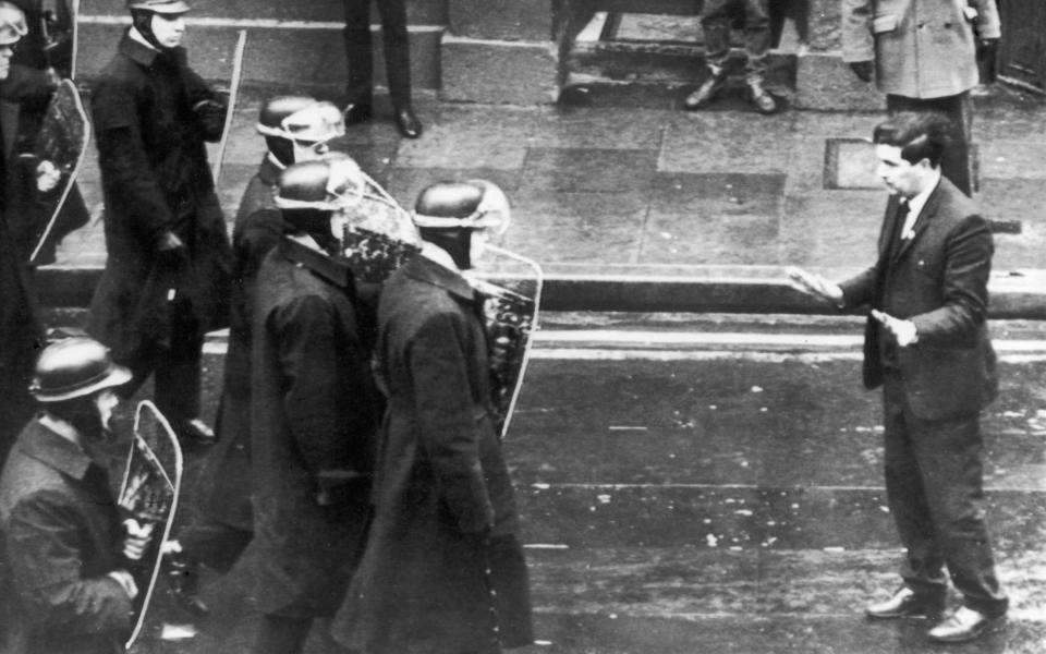 Helmeted riot police with shields move in to break up a mob of demonstrators as the civil rights leader John Hume steps into their path pleading with them not to use violence, in the centre of Londonderry, April 1969  - Daily Mirror/Mirrorpix/Mirrorpix via Getty Images