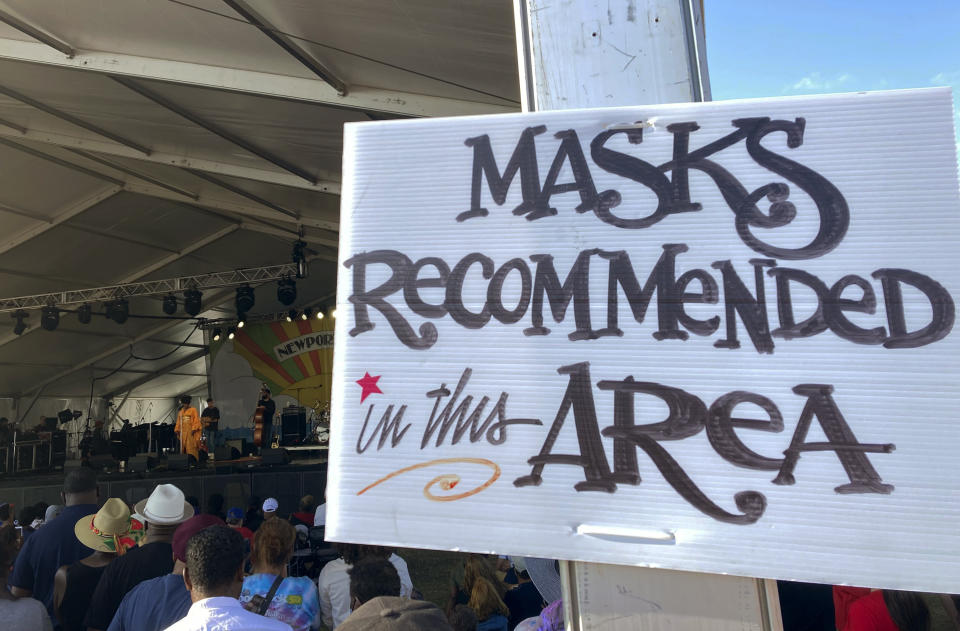 In this July 31, 2021 photo, a sign recommends attendees of the Newport Jazz Festival wear masks in a tented area where singer Ledisi performs in Newport, R.I. Festival-goers were also required to digitally upload proof of COVID-19 vaccination or a recent negative test. (Matt O’Brien/AP Photo)