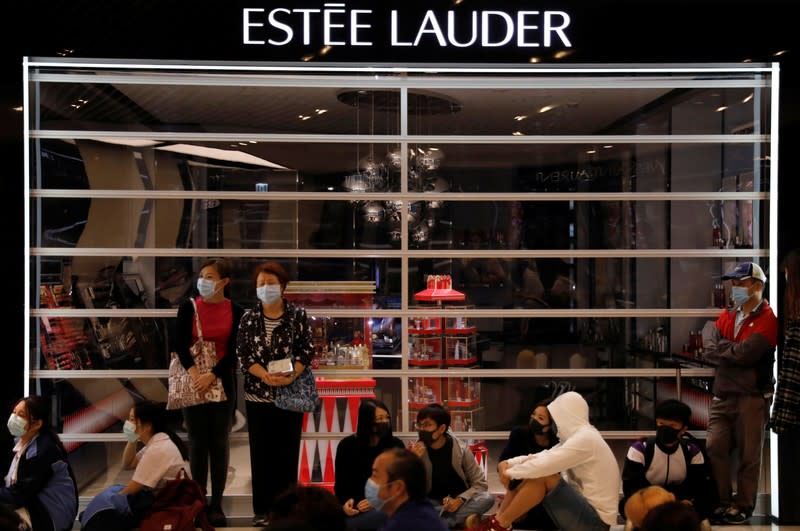 Protesters sit outside a closed shop during an anti-government protest at Yoho Mall in Yuen Long, Hong Kong