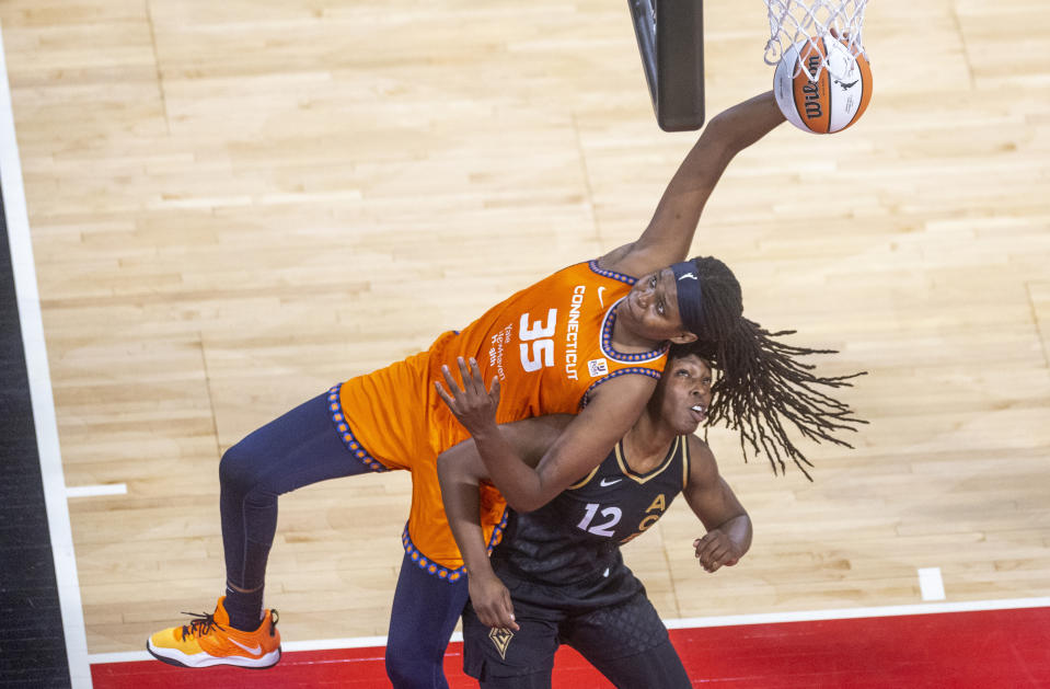 Connecticut Sun forward Jonquel Jones (35) battles for the ball over Las Vegas Aces guard Chelsea Gray (12) during the first half in Game 1 of a WNBA basketball final playoff series Sunday, Sept. 11, 2022, in Las Vegas. (AP Photo/L.E. Baskow)
