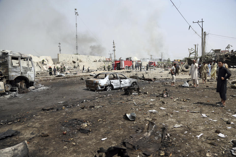 Afghas stand near the site of Monday's suicide bomb attack in Kabul, Afghanistan, Tuesday, Sept. 3, 2019. The attack occurred late Monday near the Green Village, home to several international organizations and guesthouses. (AP Photo/Rahmat Gul)