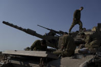 Israeli soldiers work on a tank near the Israeli-Gaza border in southern Israel, Tuesday, Jan. 16, 2024. (AP Photo/Leo Correa)
