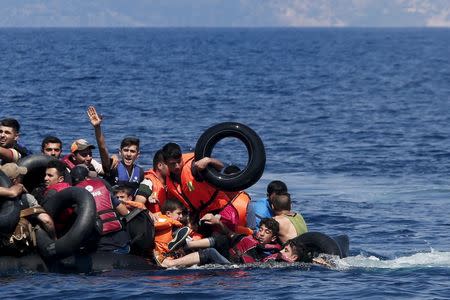 Syrian and Afghan refugees fall into the sea after their dinghy deflated some 100m away before reaching the Greek island of Lesbos, in this September 13, 2015 file photo. REUTERS/Alkis Konstantinidis/Files