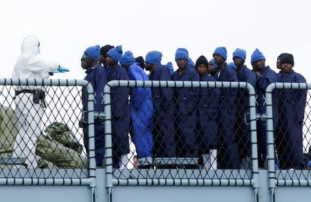 Migrants are lined up as they disembark the German naval vessel Frankfurt Am Main in the Sicilian harbour of Pozzallo, Italy, March 16, 2016. REUTERS/Antonio Parrinello