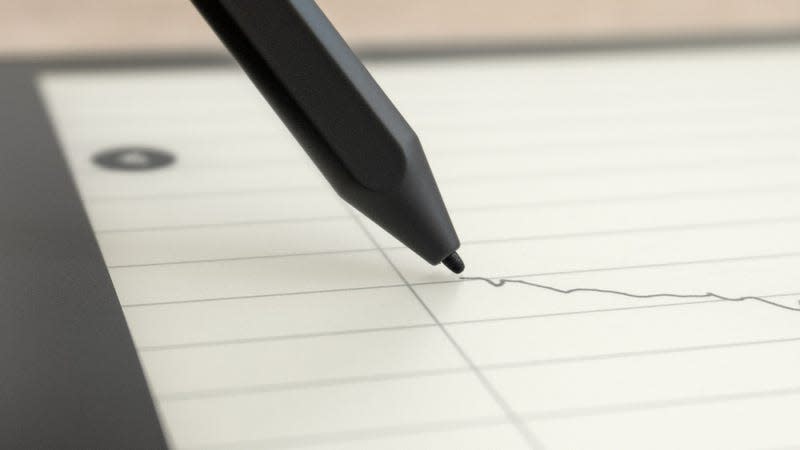 A close-up of the Kindle Scribe's Premium Pen stylus writing on the Scribe's screen.