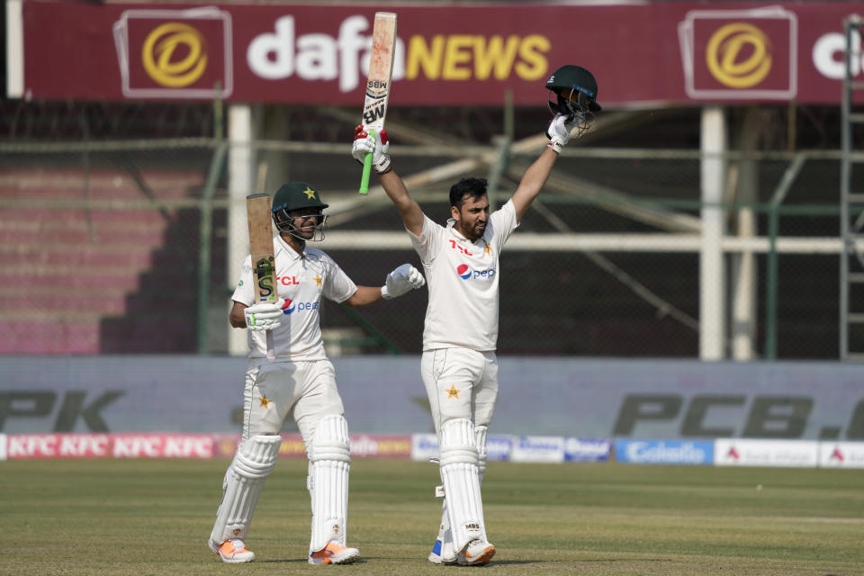 Pakistan's Agha Salman, center, celebrates after scoring century as teammates Abrar Ahmed watches during the second day of first test cricket match between Pakistan and New Zealand, in Karachi, Pakistan, Tuesday, Dec. 27, 2022. (AP Photo/Fareed Khan)