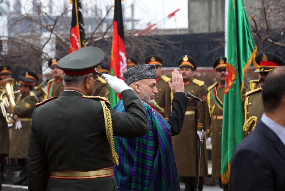 Afghan President Hamid Karzai, center, arrives at an opening session at the parliament house in Kabul, Afghanistan, Saturday, March 15, 2014. Karzai said the last 12 years of war were "imposed" on Afghans, a reference to the U.S.-led invasion that ousted the Taliban. (AP Photo/Rahmat Gul)