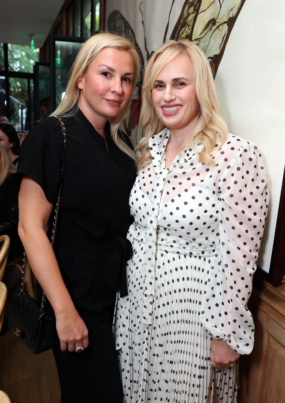 Ramona Agruma and Rebel Wilson seen at "Masters of the Air" Special Screening and Reception at San Vicente Bungalows in Los Angeles wearing minimalistic shoes