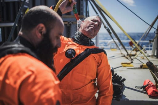 Divers rinse themselves with clean water after a dive to the seamount